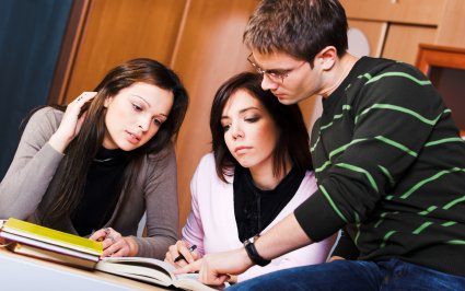 A young teacher with two English students taking a private class