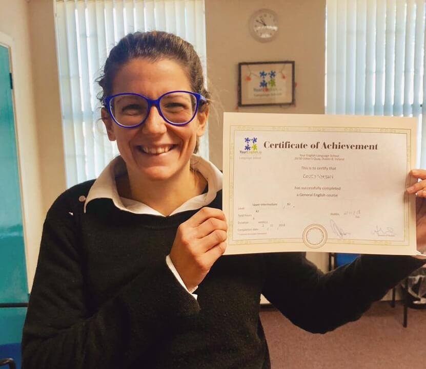 A girl holding her English certificate