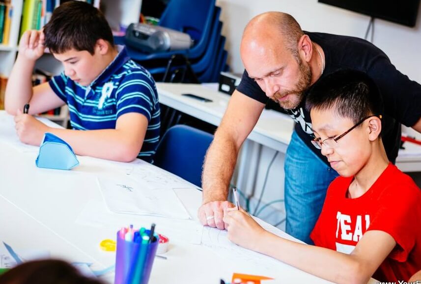 A summer school junior student aged 10 with his English teacher during morning classes at Your English Language School