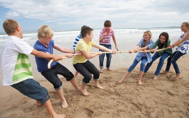 Les élèves jouent à la corde sur une plage